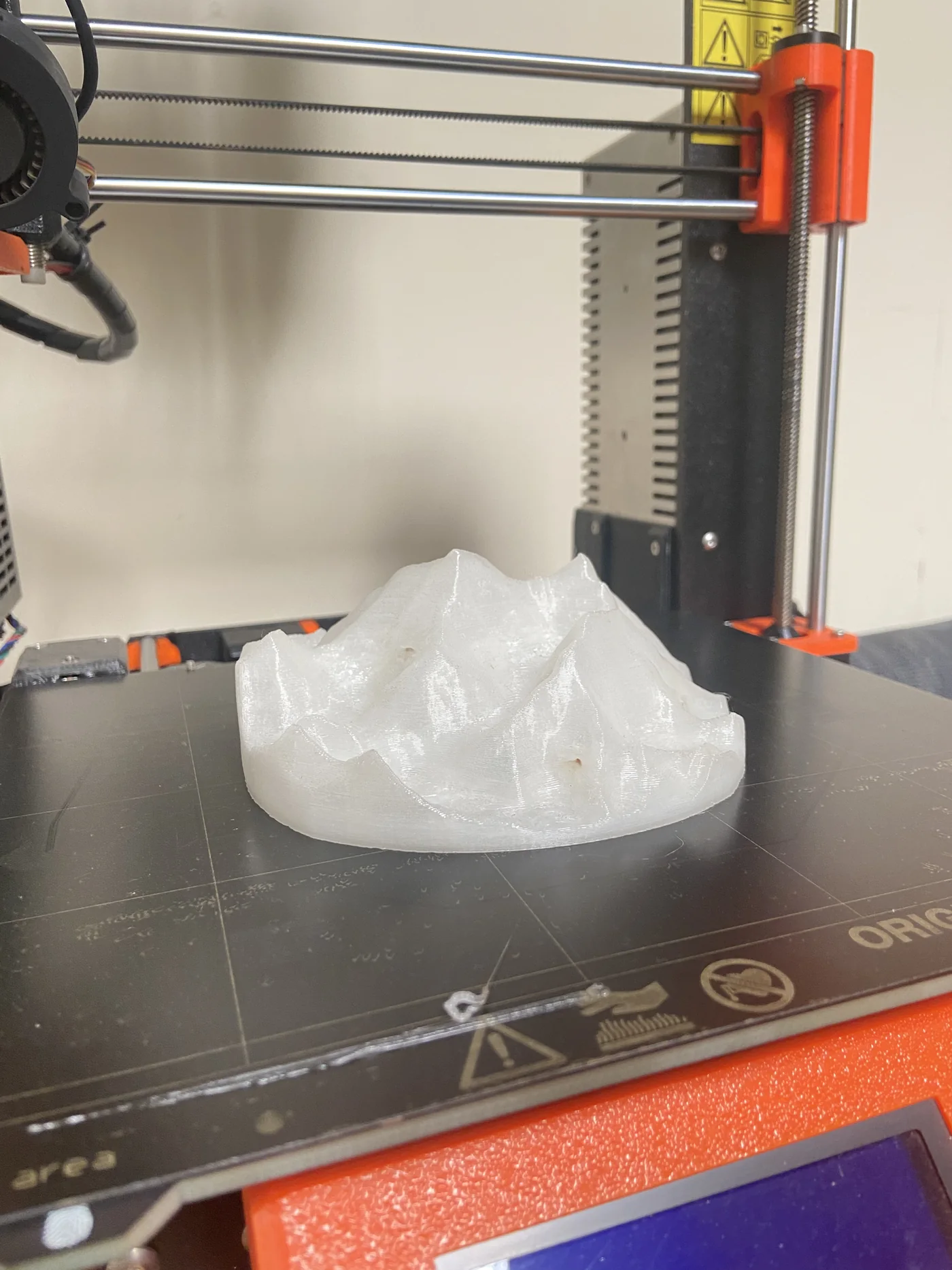 A terrain model part-printed in white PLA on the heated bed of an Original Prusa i3 printer.