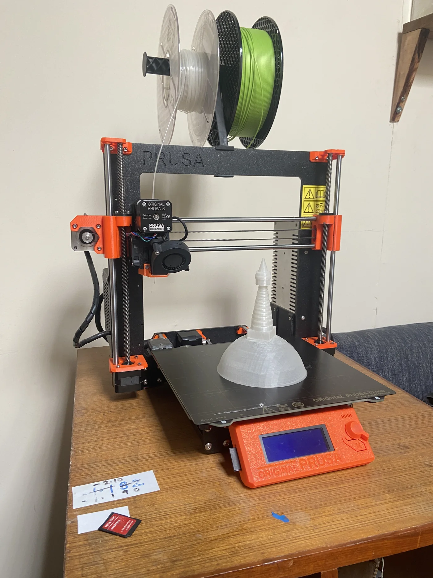 A Swayambhu stupa model printing on an Original Prusa i3, with filament spools mounted above.